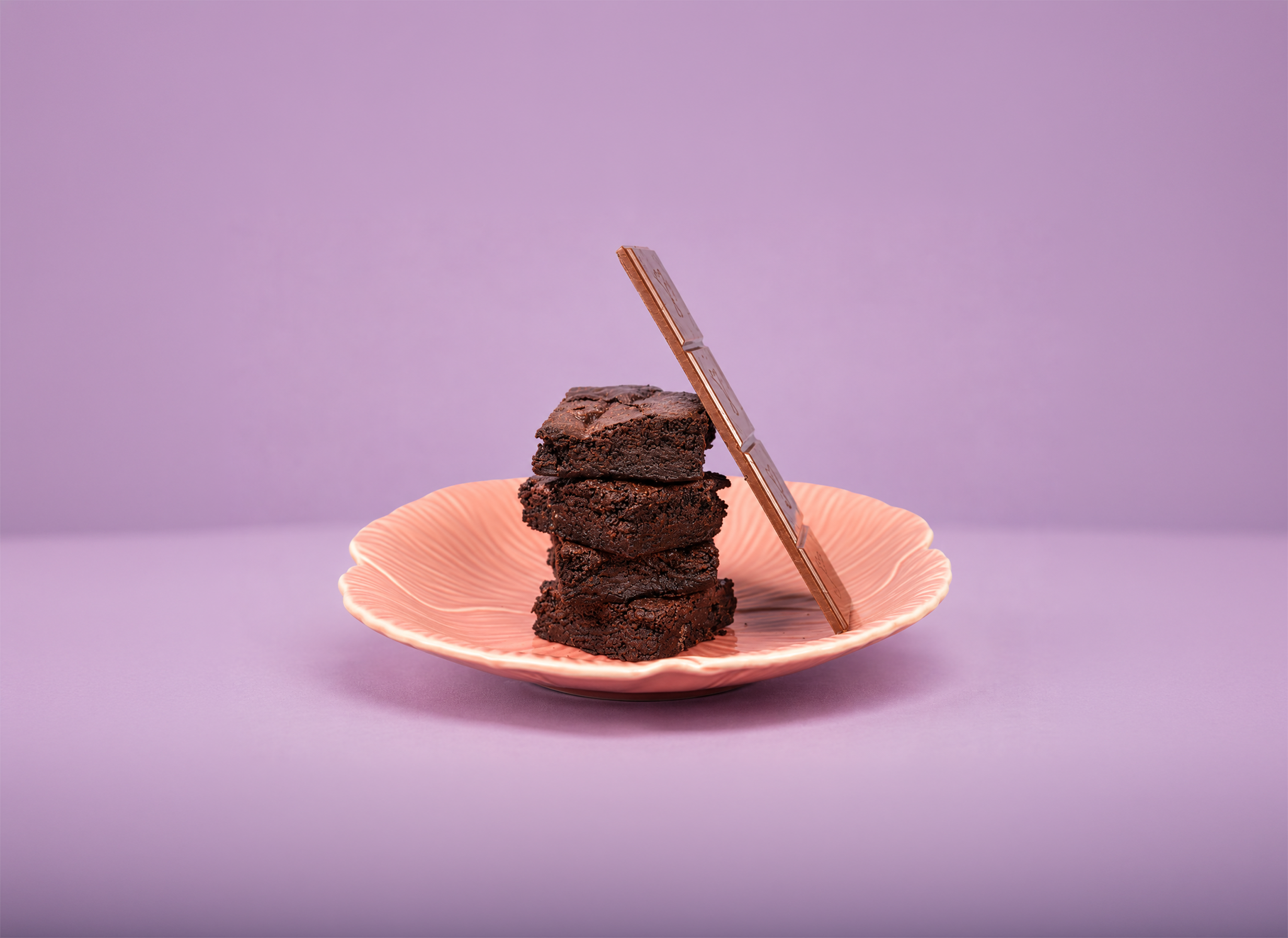 Stacked chocolate brownies on a pink plate