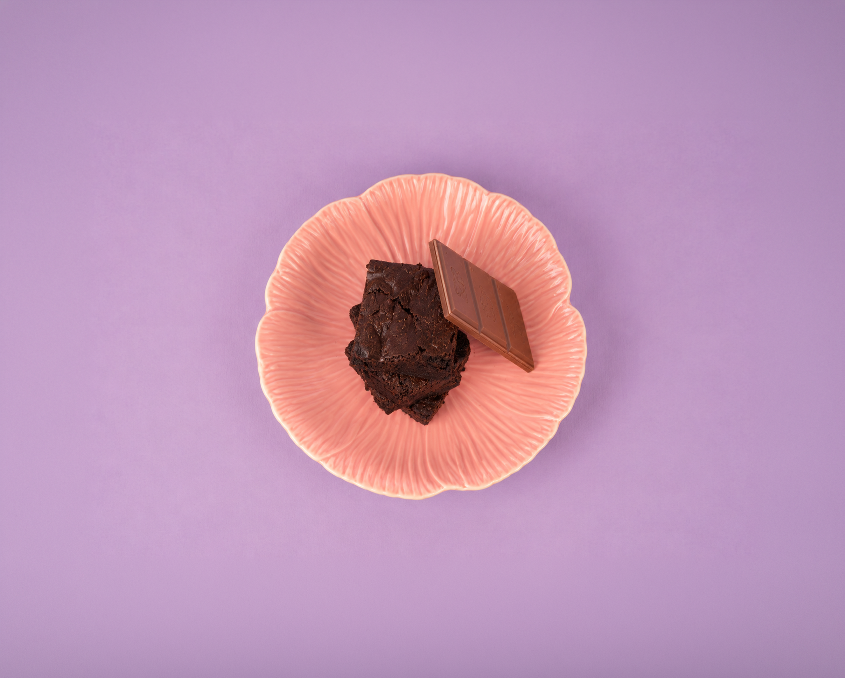 Chocolate brownies and chocolate on a pink plate