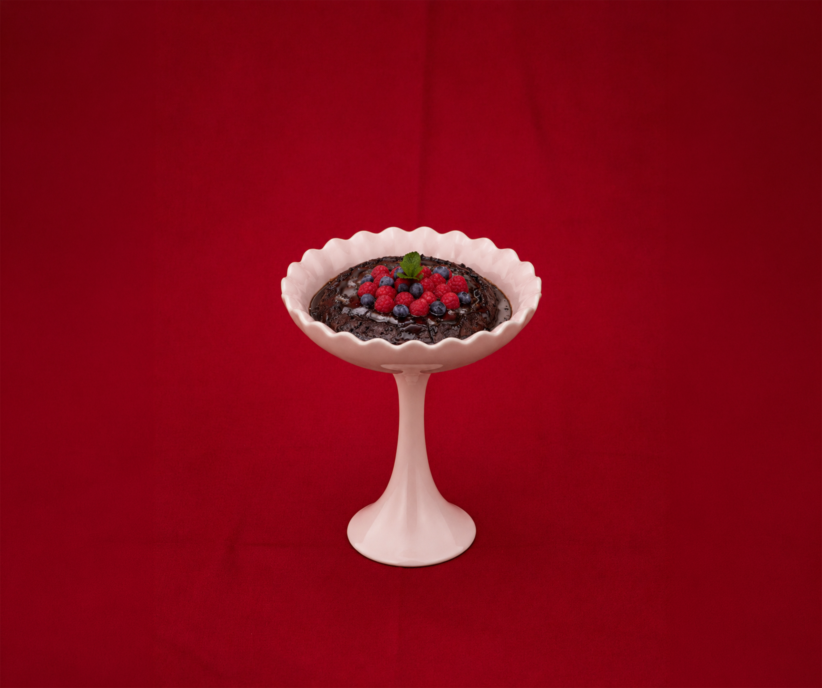 Chocolate pudding with berries in a pedestal bowl